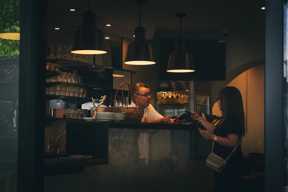 Cliente che paga al bancone di un caffè
